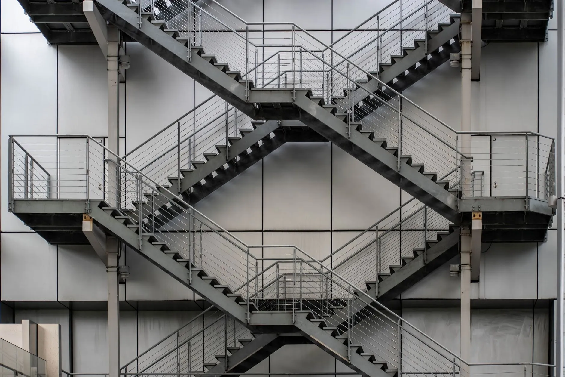 A galvanised escape stair with landings crossing the facade of a building