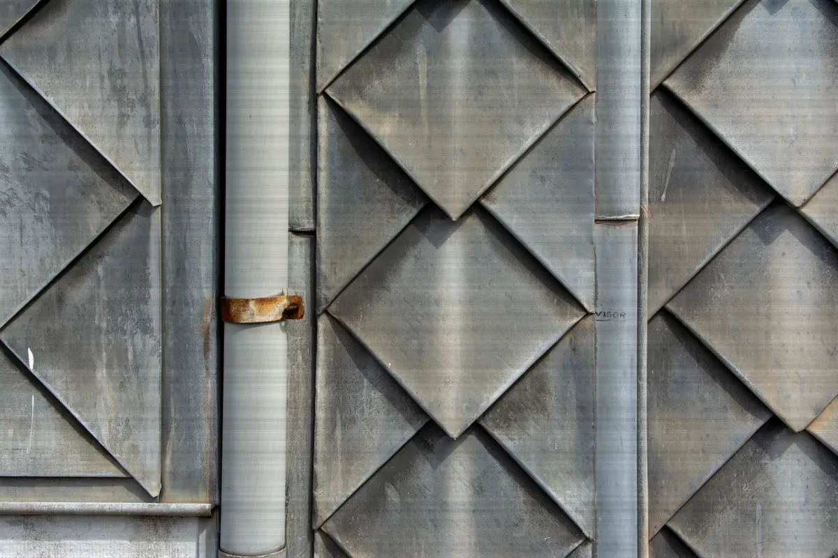 Folded steel cladding panels in a repeating diamond pattern